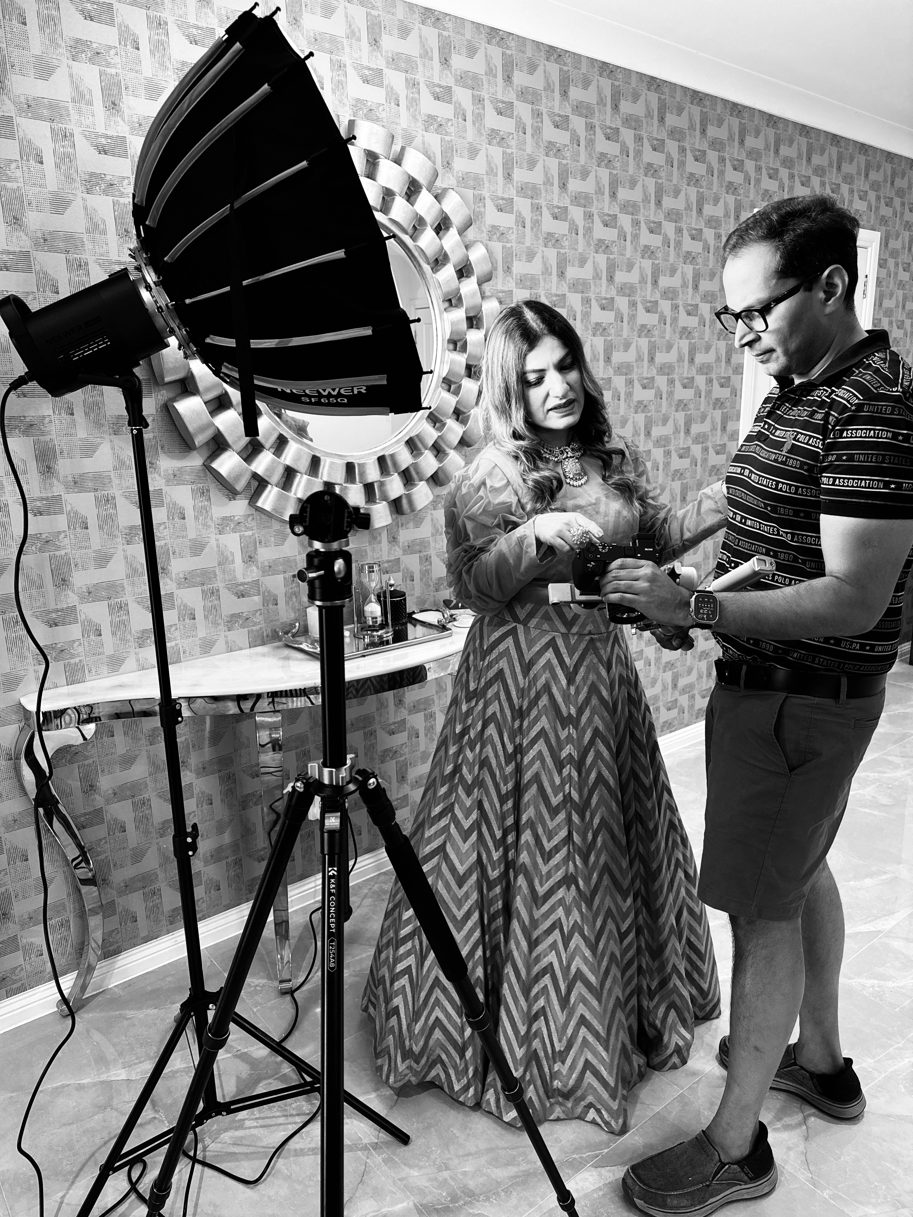 Abhishek and Divya behind the scenes reviewing camera content during a shoot